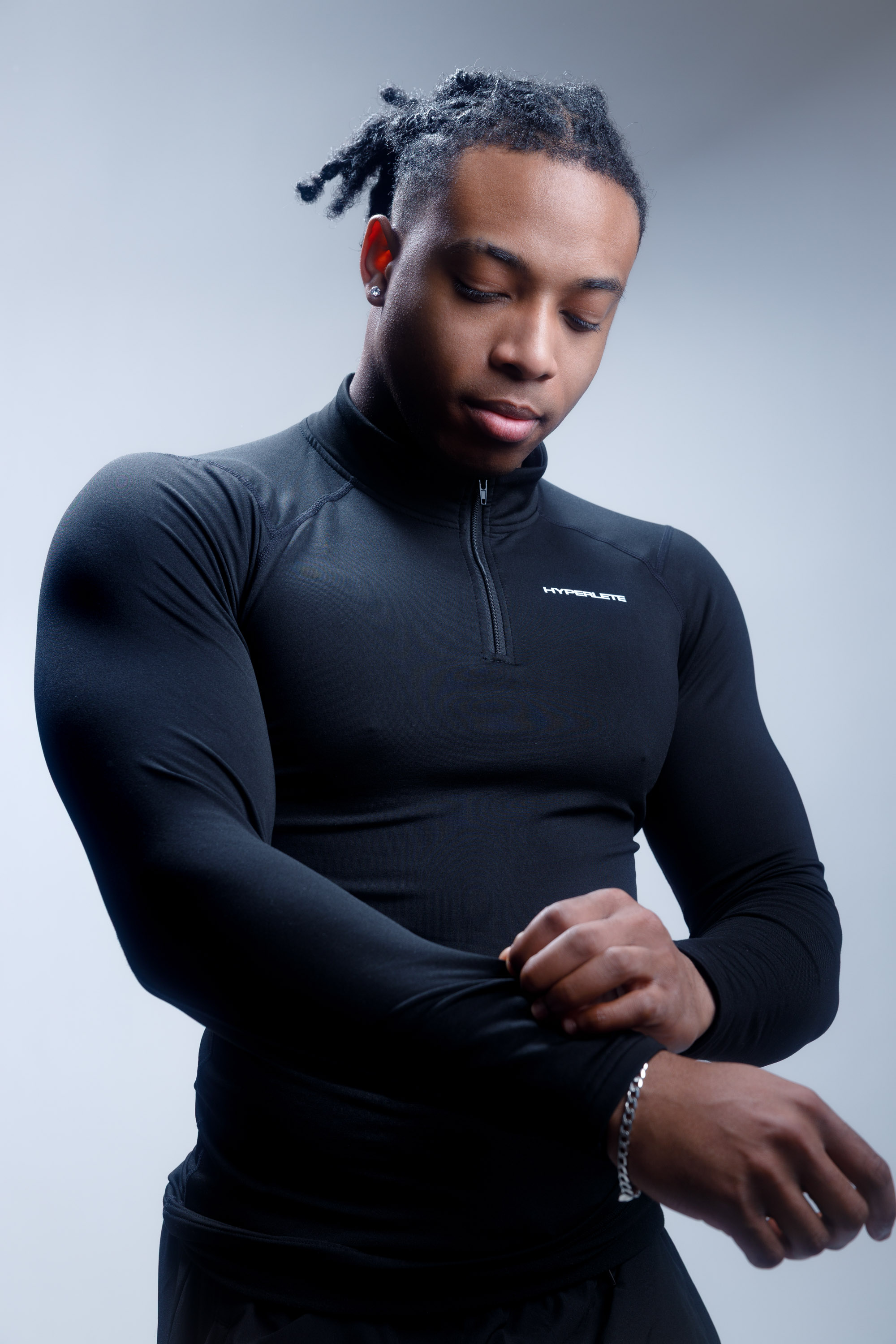 Male athlete adjusting the sleeve of a black training top
