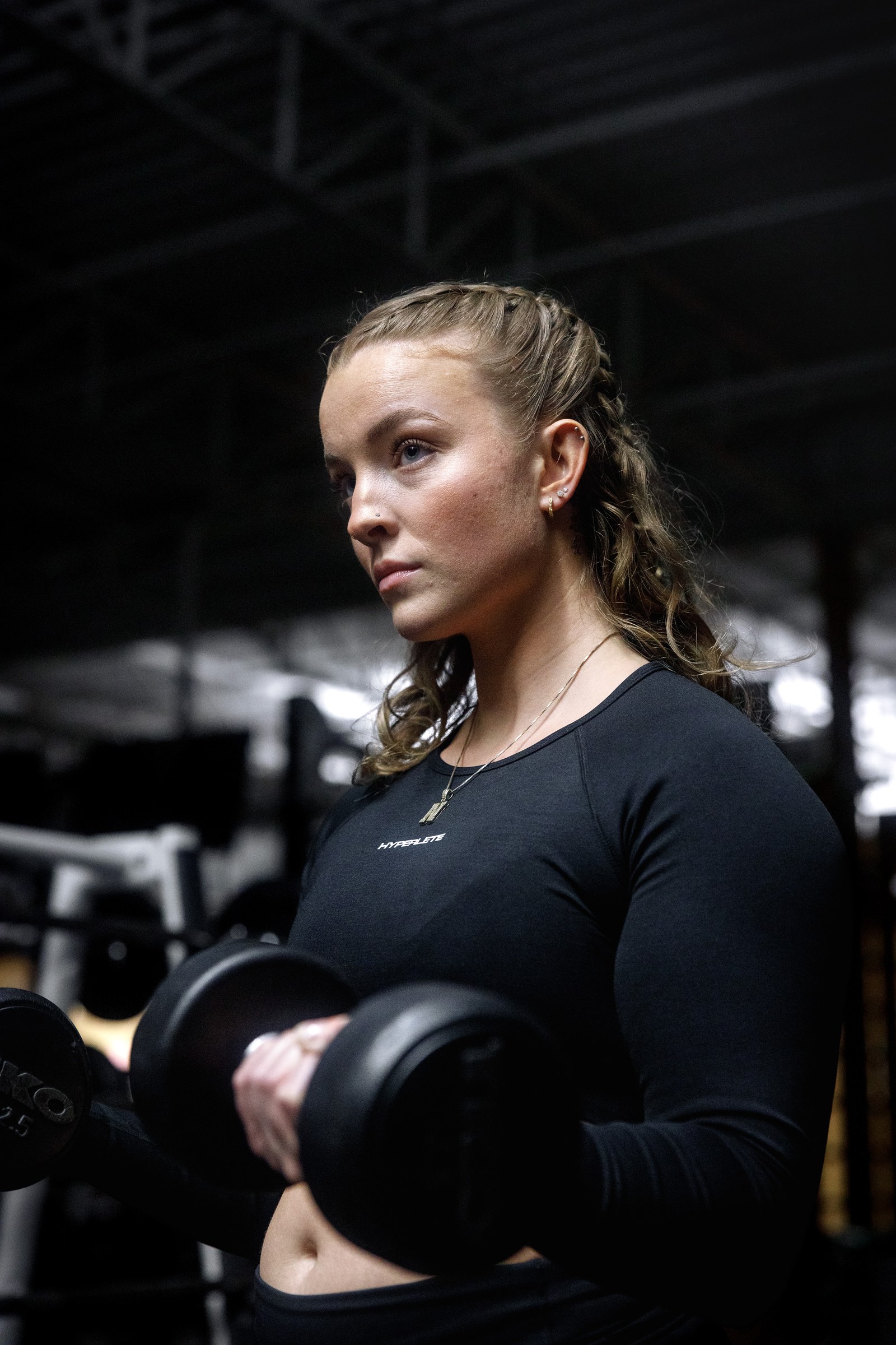 Female athlete holding dumbbells in a working gym