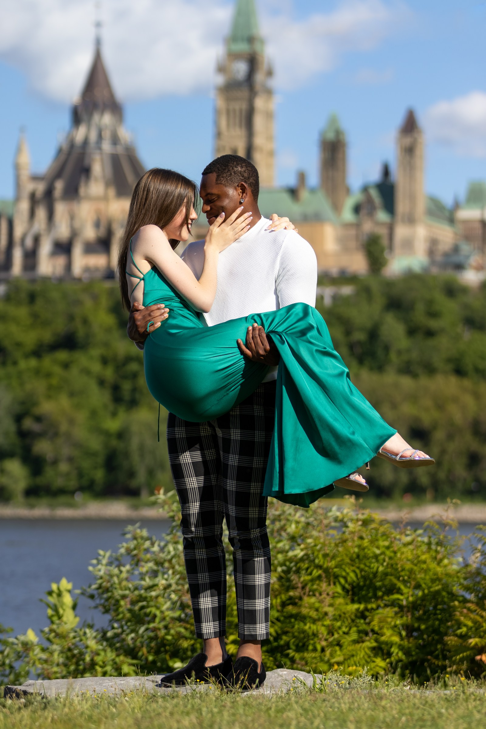 Couple sharing a playful lift with Parliament in the distance