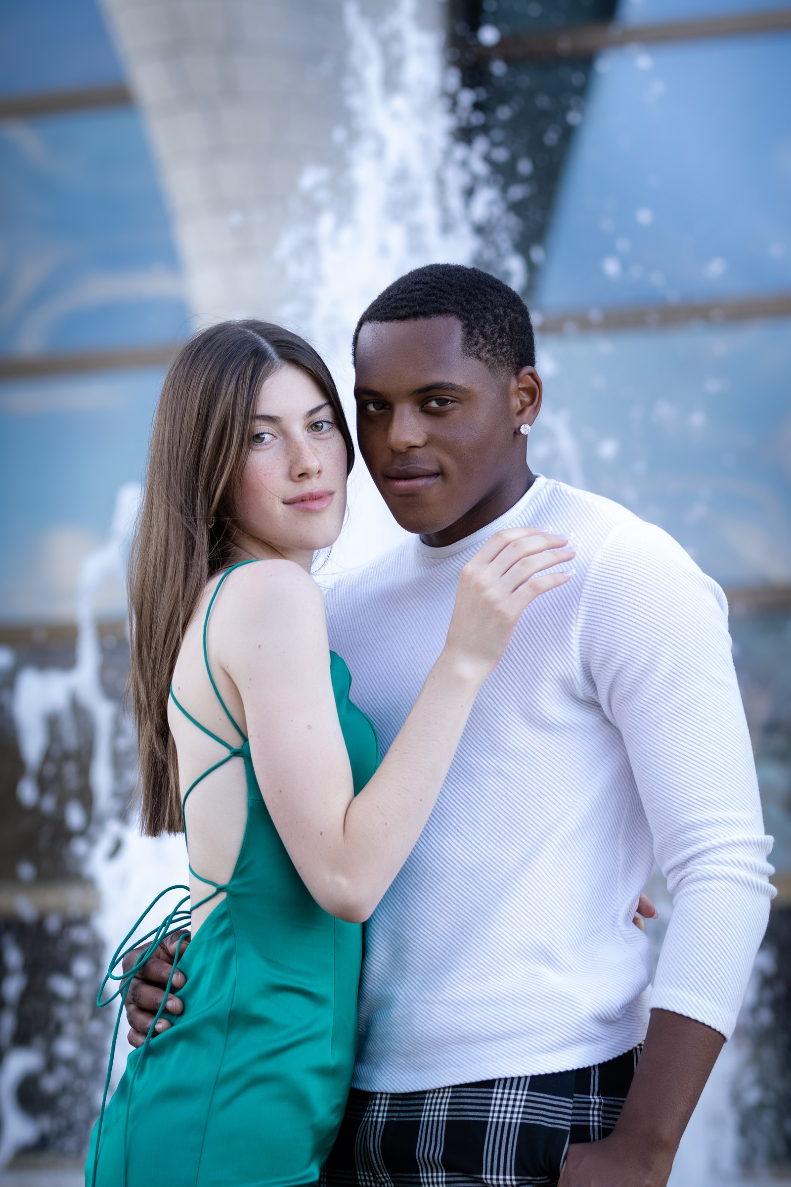 Formal couple portrait against a softly blurred city backdrop