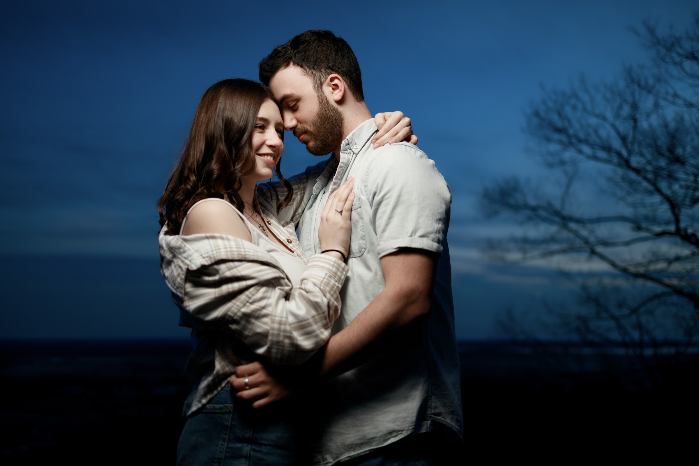 Couple sharing an intimate embrace under a deep blue sky