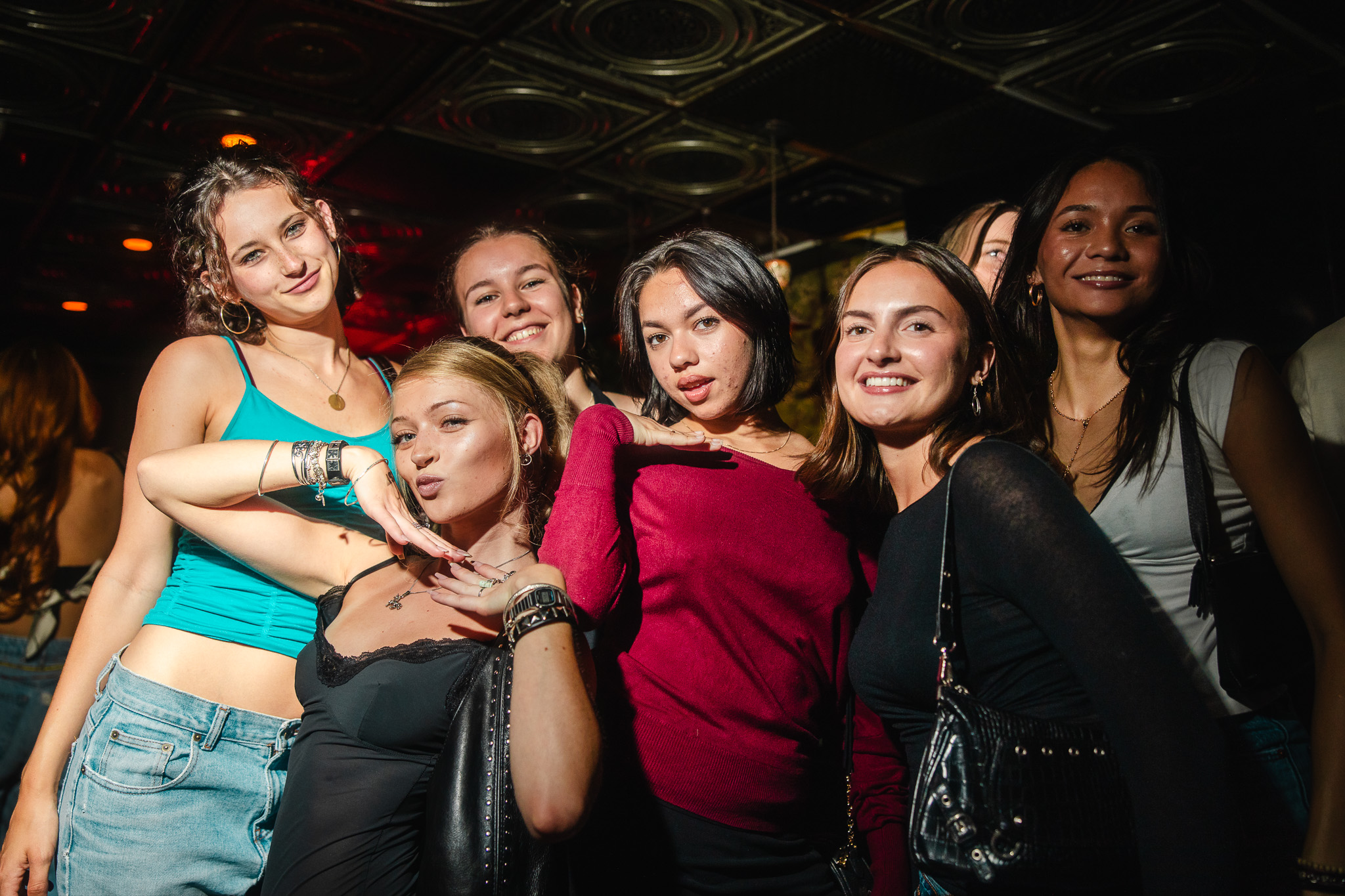 Group of friends posing together under warm club lighting
