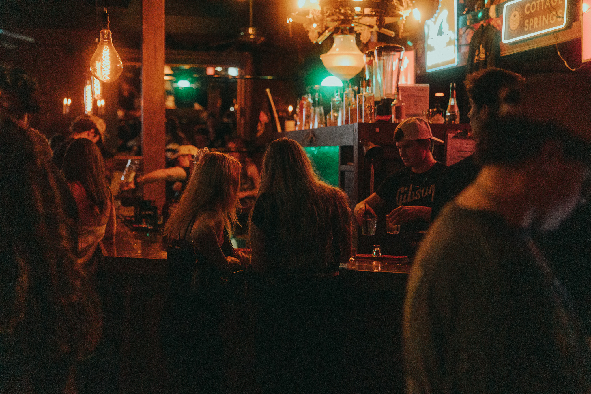 Warm atmospheric view across a busy nightclub bar