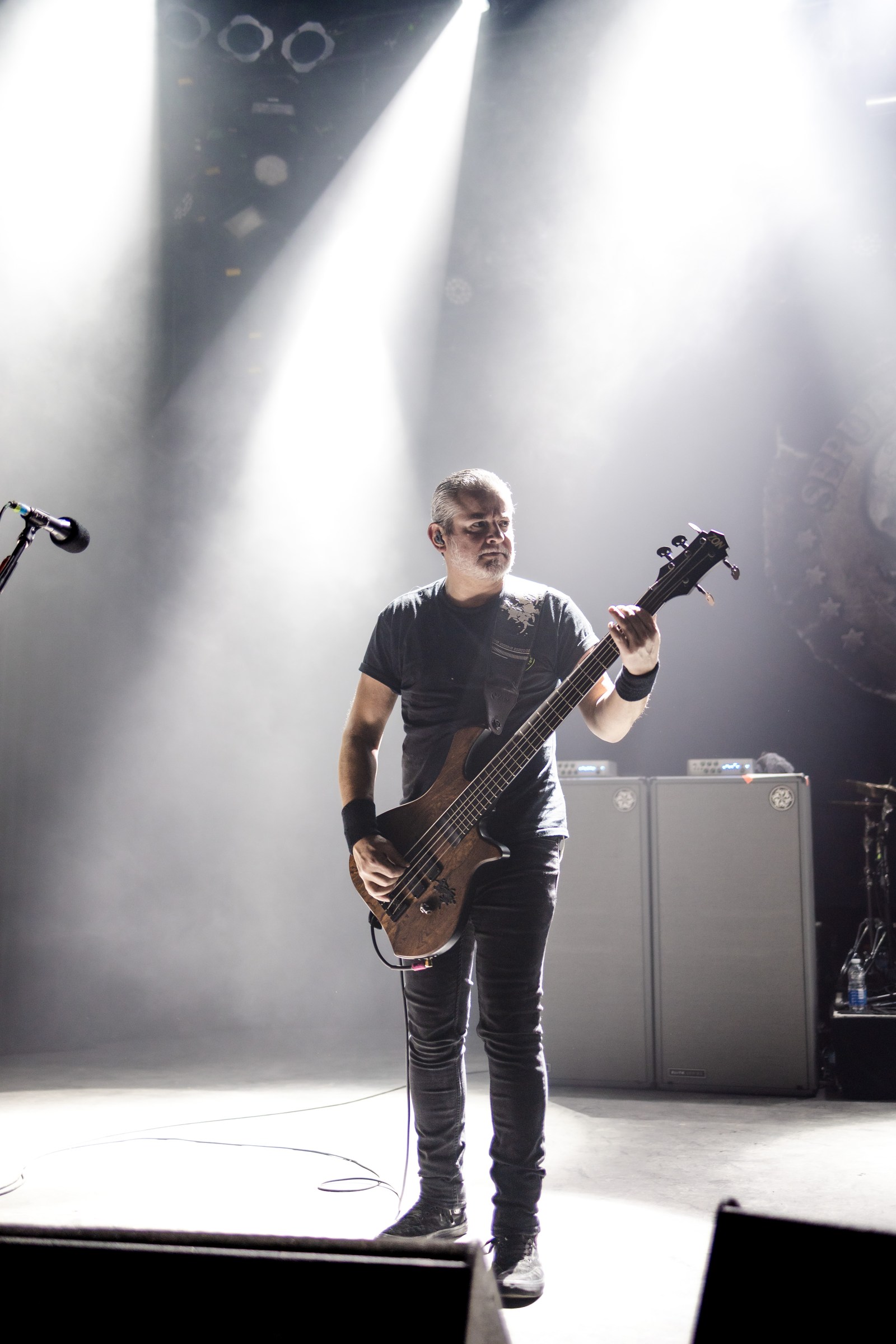 Bassist isolated in a bright column of concert light