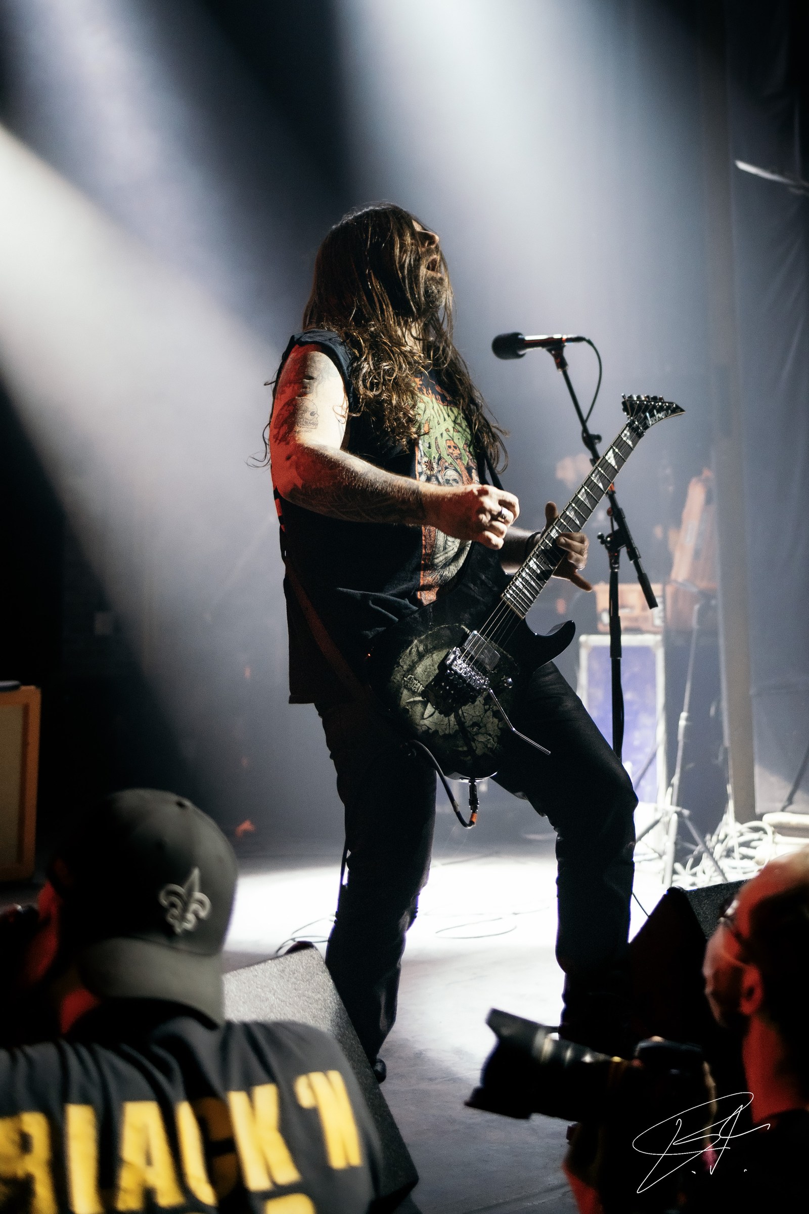 Guitarist performing beneath crisp white stage lights