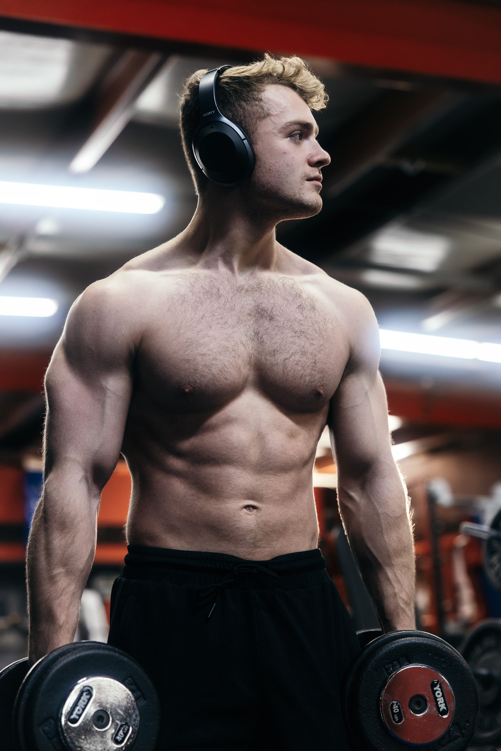 Athlete holding dumbbells in a cinematic gym portrait