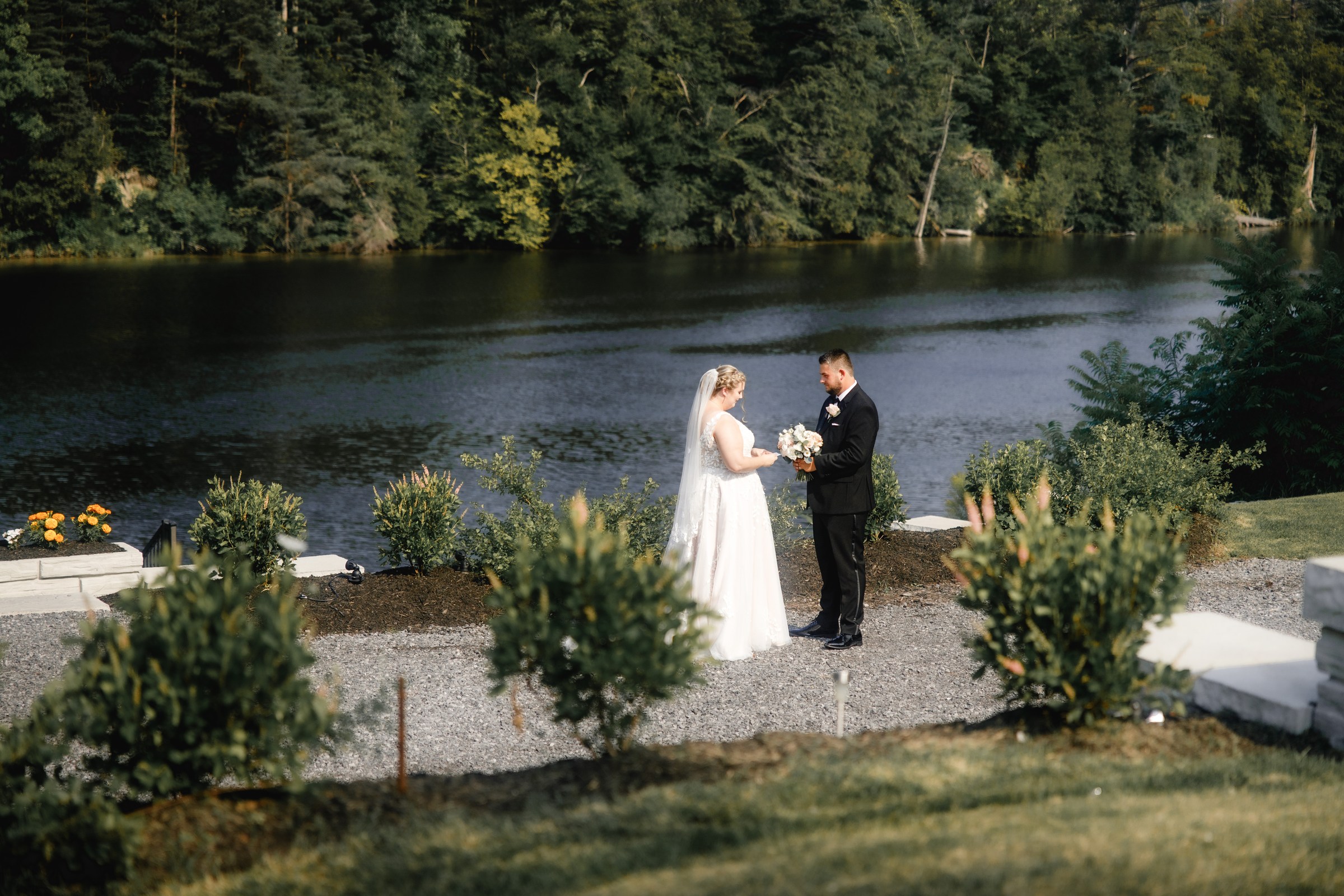 Wedding couple beside a lakeside ceremony setting