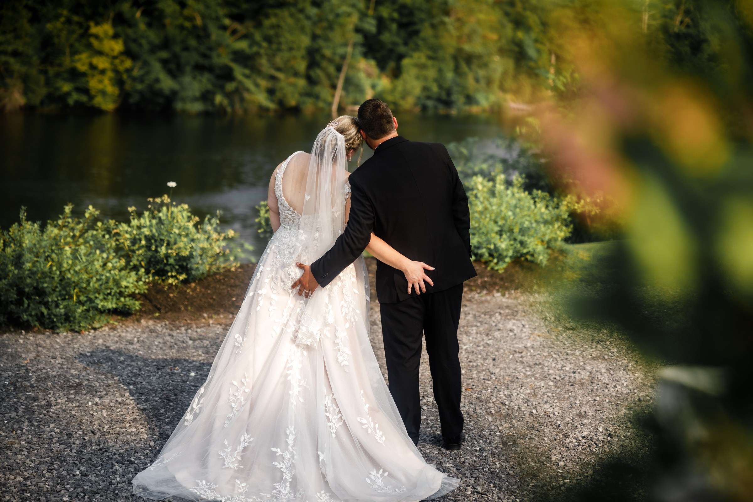 Newlyweds walking together beside the lake