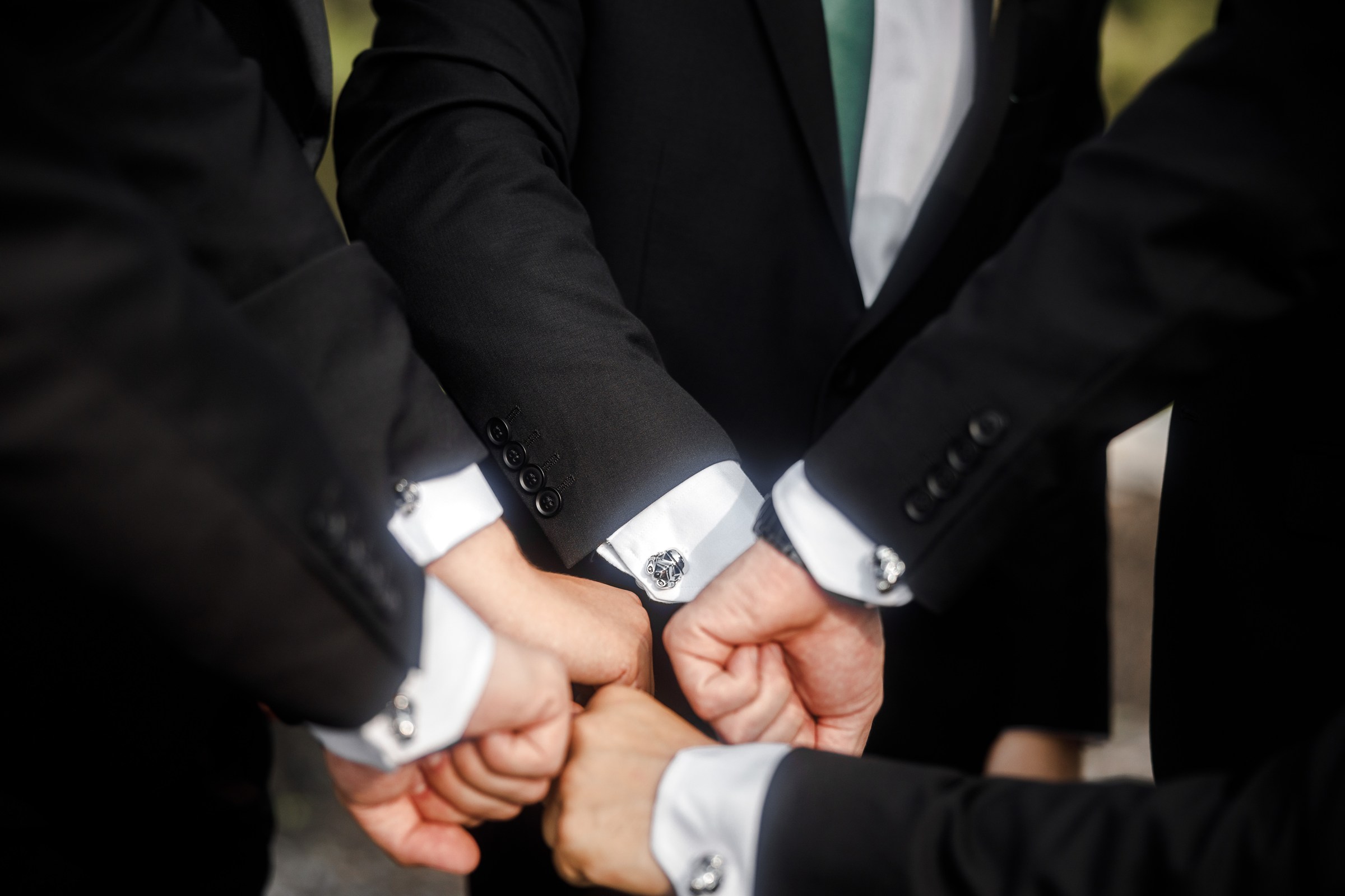 Groomsmen showing coordinated cufflink details