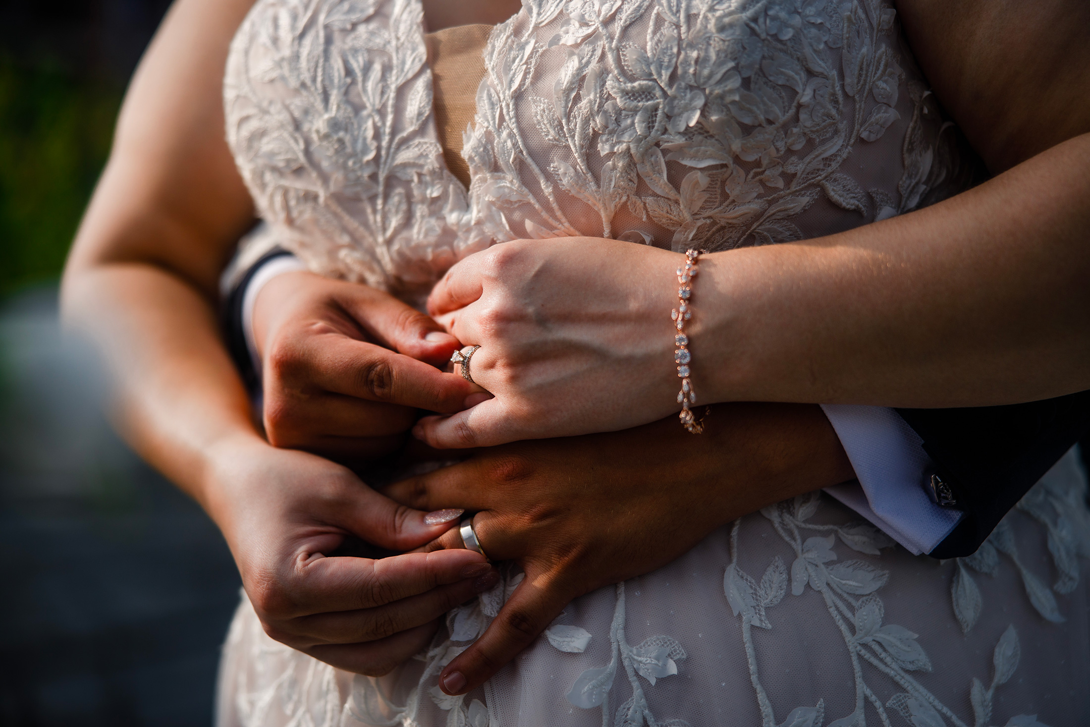Close-up wedding portrait showing a couple holding hands